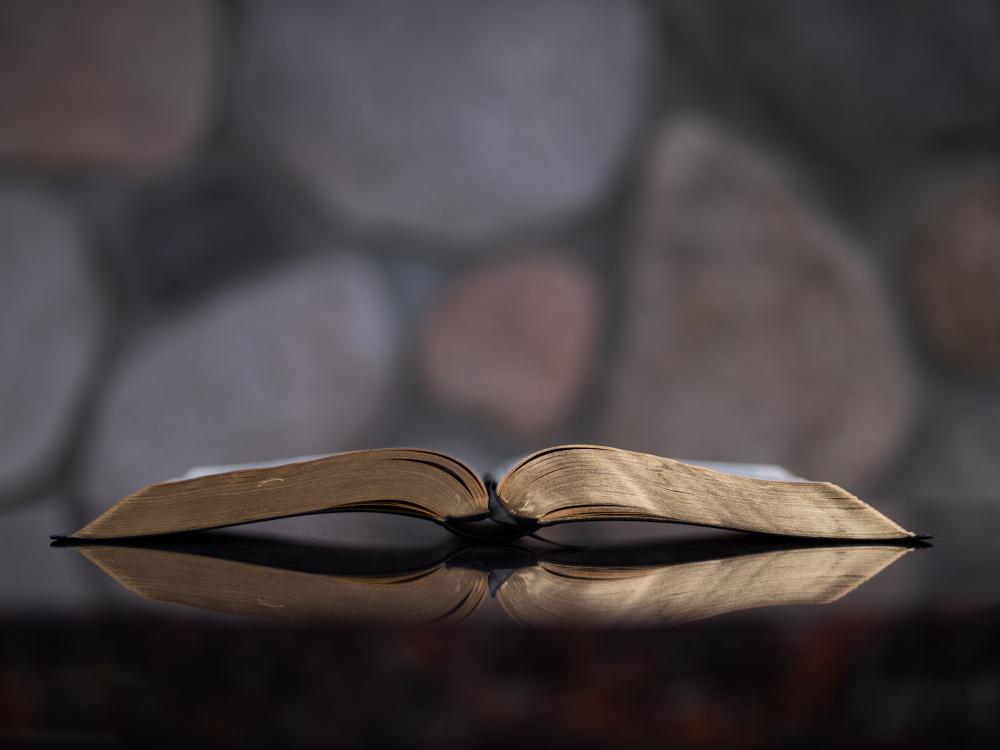 Raamattu auki pöydällä, kultaiset reunat näkyvillä, kuva Aaron Burden, Unsplash