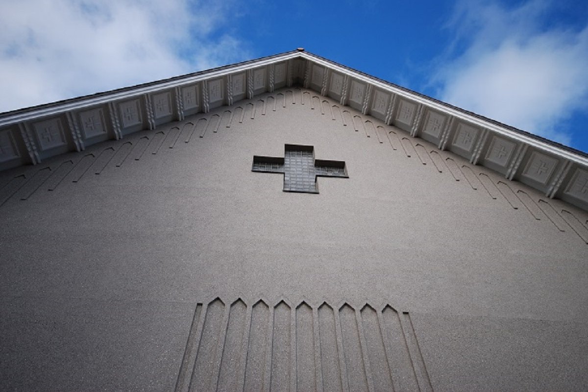Enontekiön kirkon ulkoseinä, risti-ikkuna kiviseinässä