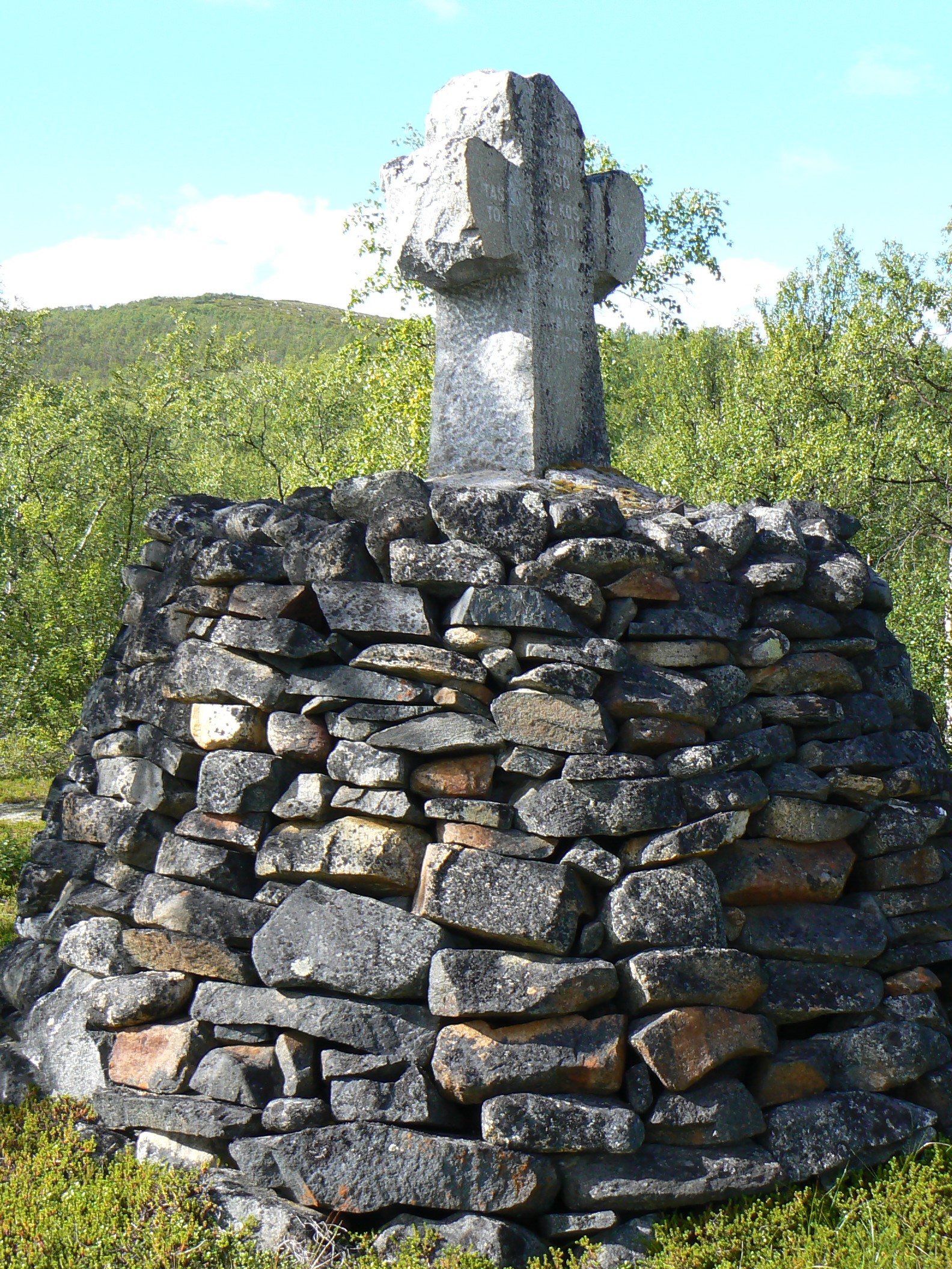 Kivinen muistomerkki, jossa risti kivikasan päällä 